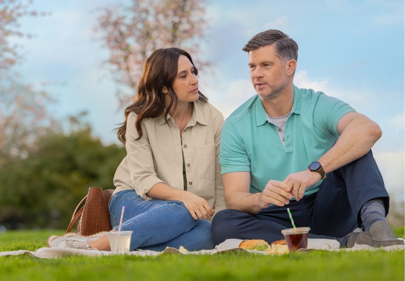 Actor portrayal of an HD patient and their caregiver relaxing and having a picnic